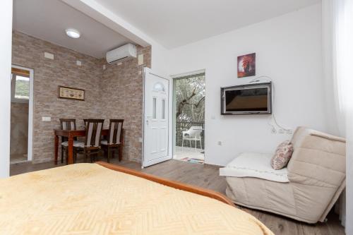 a room with a bed and a couch and a tv at Apartments Oliva in Utjeha