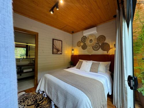 a bedroom with a bed in a room at Vale dos Bugres Eco House- Cabana das Flores in Urubici