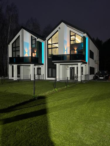 a large white house with a green lawn in front of it at VIP GOLD Warszawa Parking FREE in Stefanowo