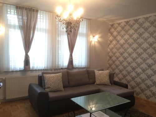 a living room with a couch and a chandelier at Apartments Vila Cvetka Bled in Bled