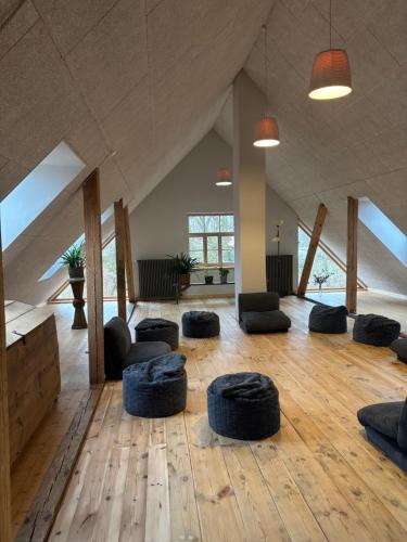 an attic room with a large room with chairs and tables at Ielejas A place for cool living in Vircava