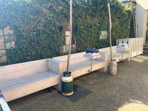 a row of wooden benches with flowers in them at Herberg Ferwert De Kr oon van Marijn in Ferwerd