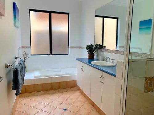 a bathroom with a tub and a sink and a bath tub at Troon Retreat! Golf, Wineries, beaches in Dunsborough