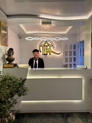 a man standing behind the counter of a restaurant at Hotel KASTURI PALACE & RESTAURANT DARJEELING in Darjeeling