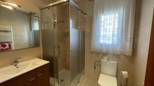 Un baño con ducha, lavabo e inodoro. en Casa Adela, en Begur