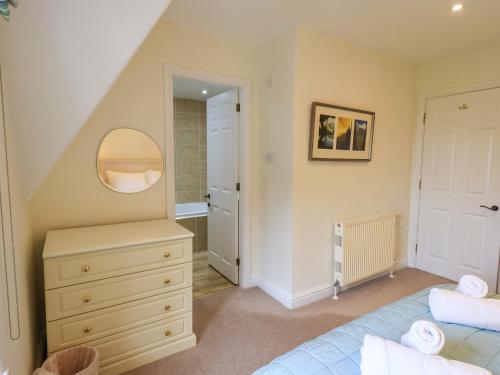 un dormitorio con una cama y un espejo en The Lookout, en Ambleside
