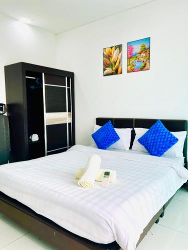 a bedroom with a large white bed with blue pillows at Summer Suites KLCC By City Home Style in Kuala Lumpur