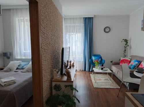 a bedroom with a bed and a living room at Apartament Arbuzowy Zachód Słońca in Pobierowo