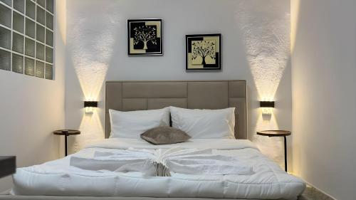a bedroom with a white bed with a book on it at Angel's Studio Apartments in Tirana