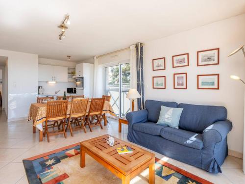 un salon avec un canapé bleu et une table dans l'établissement Appartement 4 pièces à Carnac - Vue mer, terrasse, parking, accepte animaux - FR-1-477-72, à Carnac
