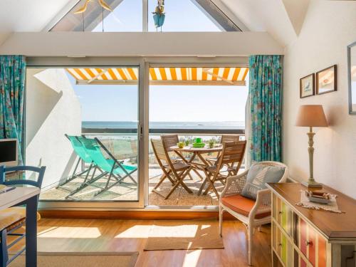 - un salon avec une grande fenêtre, une table et des chaises dans l'établissement Carnac - Duplex 2P+Mezzanine 4 pers, Terrasse Sud, Animaux admis, Parking - FR-1-477-114, à Carnac