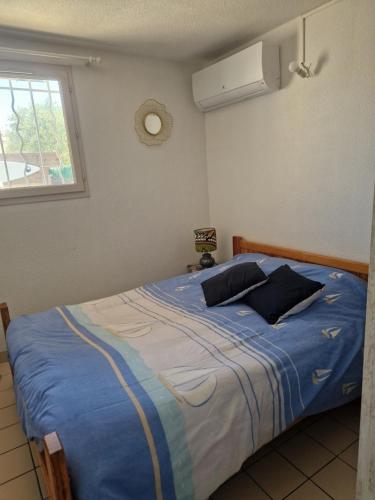 - une chambre avec un lit bleu et 2 oreillers dans l'établissement maison à louer, à Saint Cyprien Plage