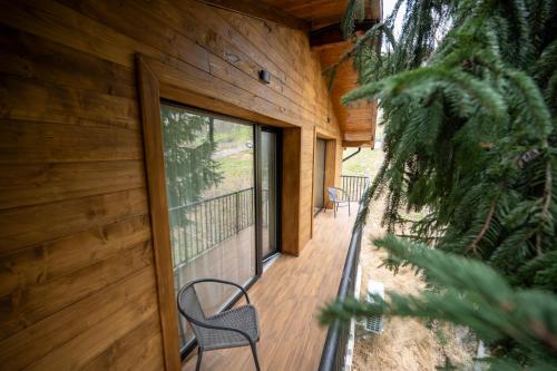 a porch of a wooden cabin with chairs on it at EDEN HOUSE Viseu de Sus in Vişeu de Sus