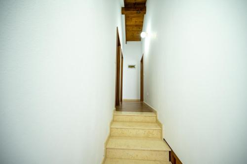 a hallway with white walls and a stair case at EDEN HOUSE Viseu de Sus in Vişeu de Sus