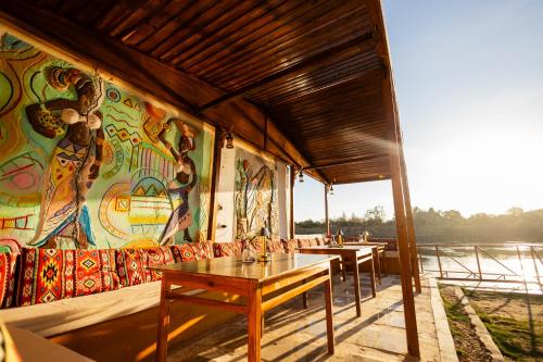 a restaurant with tables and a mural on the wall at Fenti Nubian Resort in Aswan