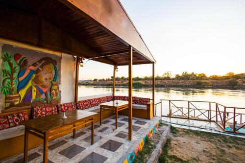a building with tables and a painting on the side of a river at Fenti Nubian Resort in Aswan