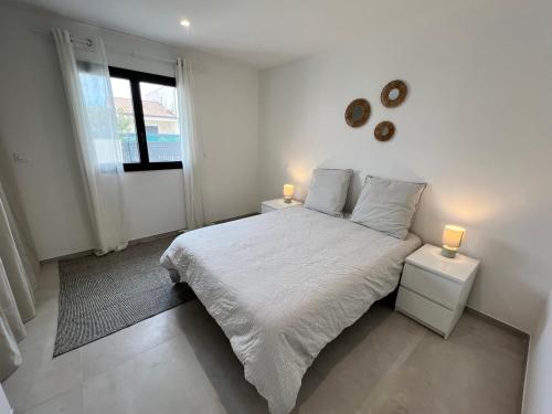 une chambre blanche avec un lit et deux tables de nuit dans l'établissement Villa d'architecte, à Port-la-Nouvelle