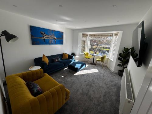a living room with a yellow couch and a table at Park view holiday apartment in Skegness