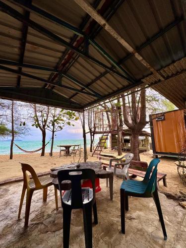 a group of tables and chairs on the beach at Pok Mat Beach Cabin in Marang