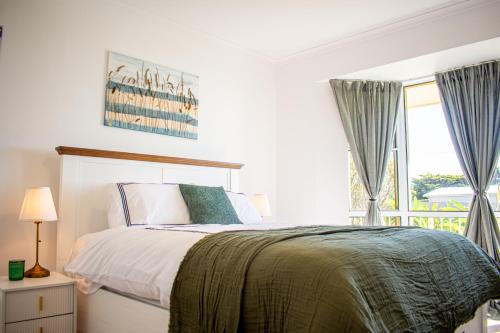 a bedroom with a bed and a large window at Pet & Family Friendly 3BR Coastal Escape Near Boat Ramp - Diyamba! in Encounter Bay