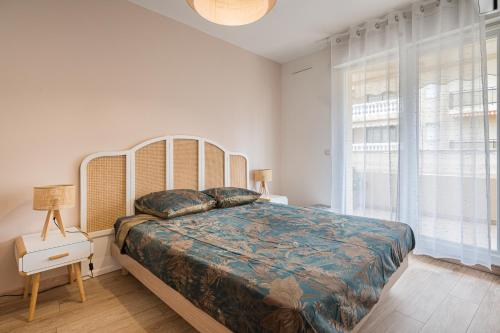 une chambre avec un grand lit et une grande fenêtre dans l'établissement Magnifique 2 pièces, Clim, parking , wifi, à Beaulieu-sur-Mer