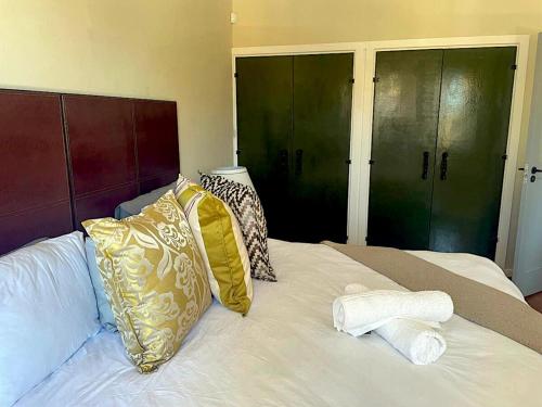 a bed with towels and pillows on top of it at Mount Road Suites in Port Elizabeth