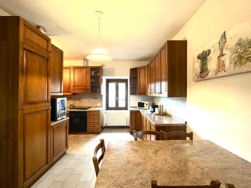 a kitchen with wooden cabinets and a table with chairs at Il portico del Lago in Varese