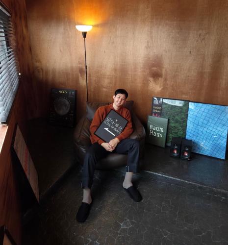 a man sitting in a chair with a laptop at ILDA Busan Licensed 3 Rooms 4 KingBeds 2 Bathrooms 2 Subway stations in Busan