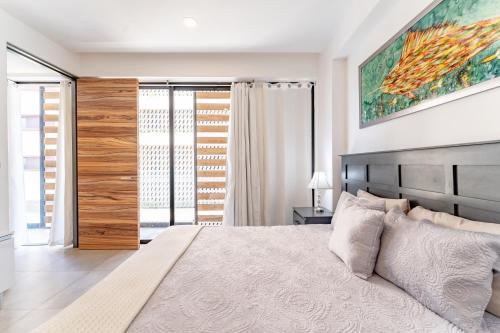 a bedroom with a large bed and a large window at Condo at Icono 3 Bedrooms close 5th in Playa del Carmen