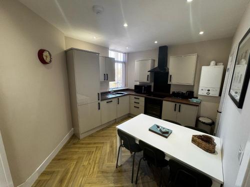 a kitchen with a table and a white counter top at Park view holiday apartment in Skegness