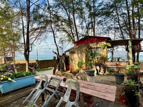 a garden with a wooden bench and a house at Pok Mat Beach Cabin in Marang