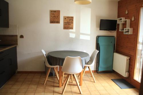 une cuisine avec une table et des chaises et une télévision dans l'établissement VOINETTES VNB8 TELECABINE & MOUNTAIN 4 Pers, à Châtel