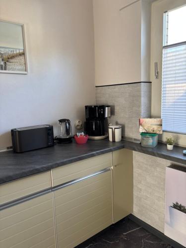 a kitchen with a counter top with pots and pans at Ferienwohnung Hygge und Mee-h-r in Brunsbüttel
