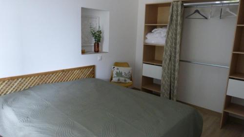 - une chambre avec un lit dans une pièce dotée d'étagères dans l'établissement La petite maison, à Mézières-en-Brenne