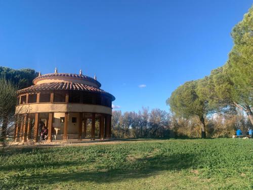 un edificio circolare in un campo alberato sullo sfondo di BLISS HOME Lagunas de Villafáfila a Villalba de la Lampreana