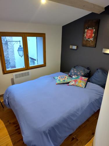 ein Bett in einem Schlafzimmer mit zwei Kissen darauf in der Unterkunft Maison avec jardin au coeur du village in Ampus