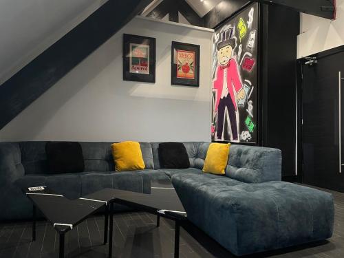 a living room with a blue couch and yellow pillows at ResiLets - The Monopoly Apartment - Large 4 bedroom in Bedlington