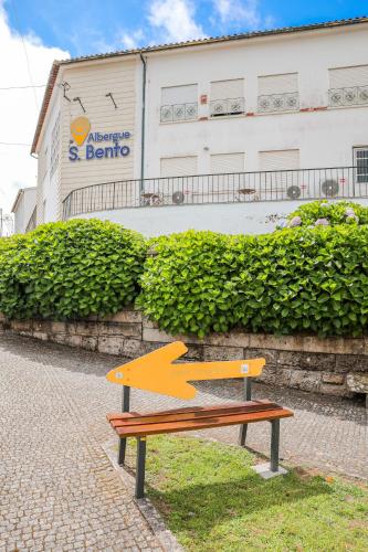a wooden bench sitting in front of a building at Albergue de São Bento in Caminha