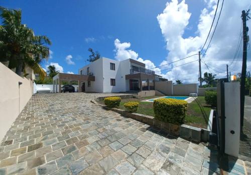 a house with a stone driveway in front of a house at Villa Camille & Villa Shaheen in Trou dʼ Eau Douce