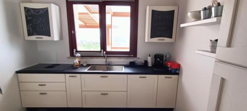 a kitchen with a sink and a window at Corte D'Alì in Raffadali