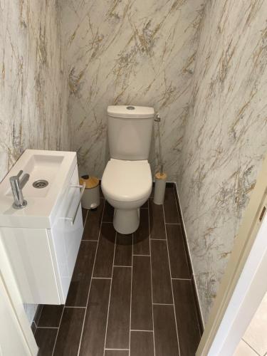 une salle de bain avec des toilettes blanches et un lavabo dans l'établissement maison individuelle, à Corsept