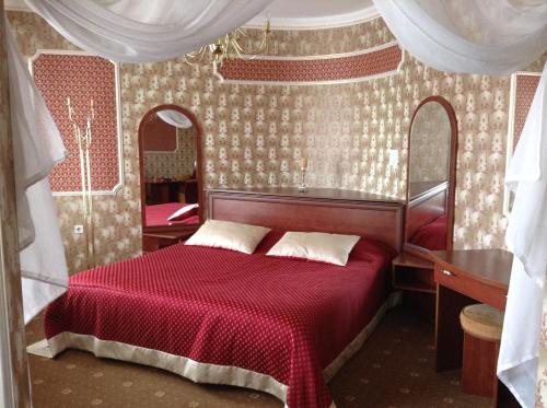 a bedroom with a red bed with a red blanket at Hotel Serpanok in Tyachiv