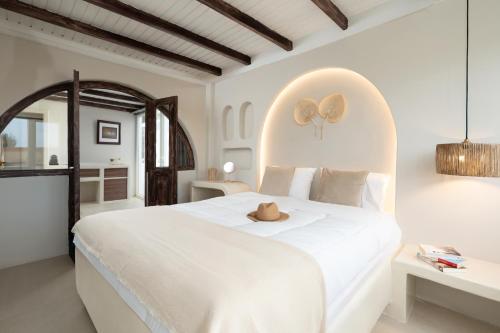 a bedroom with a large white bed with a stuffed animal on it at Paridian Elegant Living in Parikia