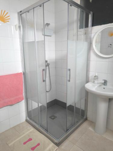 a bathroom with a shower and a sink at Albergue Por Fin in Fisterra