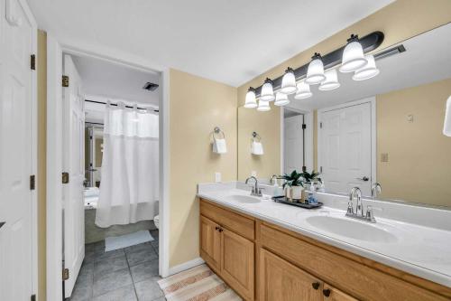 a bathroom with two sinks and a large mirror at Edgewater Tower 1-411 in Panama City Beach