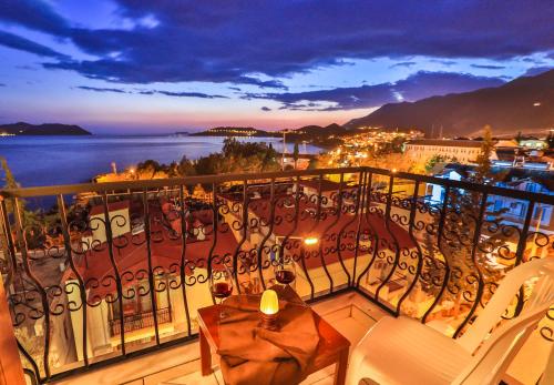 a balcony with a table and chairs and a view of the water at Hotel Kayahan in Kas
