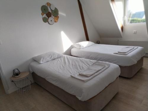 a room with two beds and a window at Maison familiale in Fontaine-la-Mallet