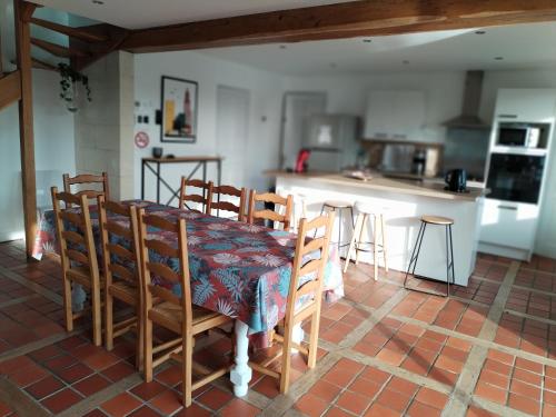 a kitchen with a table and chairs in a room at Maison familiale in Fontaine-la-Mallet