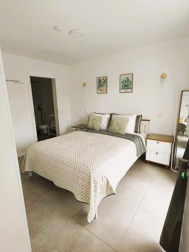 a bedroom with a large bed with a white comforter at FlorAL in Aljezur