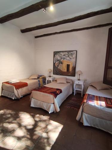 a bedroom with three beds in a room at TADASANA CASA DE CAMPO in La Carrera